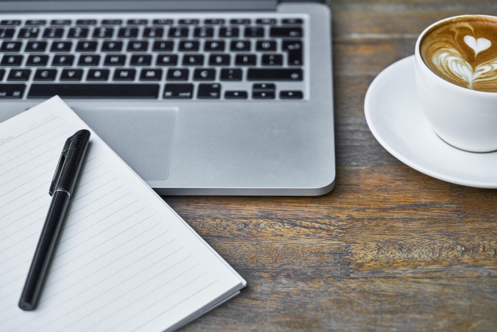 Laptop, kaffekop og notesblok – stemningsbillede fra Jessen Regnskab i Ikast